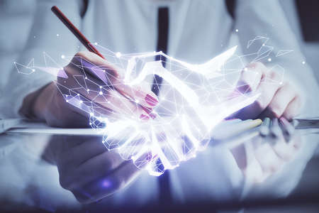 Handshake drawing over hands taking notes background. Concept of success. Double exposureの写真素材