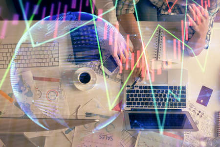Double exposure of man and woman working together and financial graph hologram drawing. market...