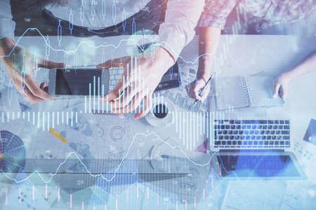 Double exposure of man and woman working together and financial chart hologram drawing. market...