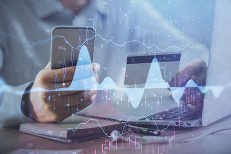 Double exposure of man hands holding a credit card and Forex graph drawing. Stock trading and...