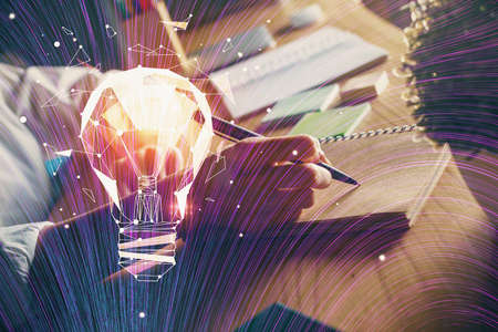 Drawing bulb over womans hands taking notes background. Concept of idea. Double exposure