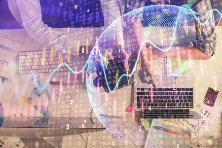 Double exposure of man and woman working together and financial graph hologram drawing. market analysis concept. Computer background. Top View.の写真素材