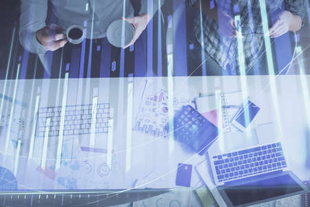 Double exposure of man and woman working together and financial chart hologram drawing. market analysis concept. Computer background. Top View.の写真素材