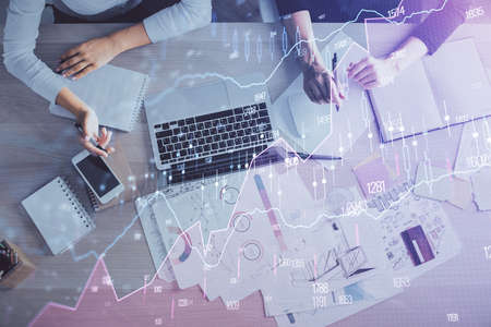 Double exposure of woman hands working on computer and forex graph hologram drawing. Top View....