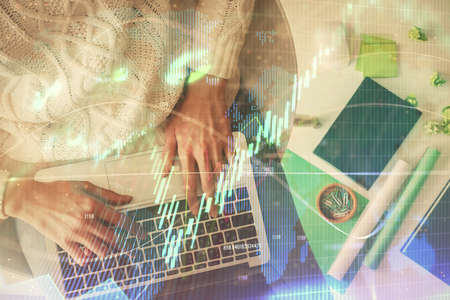 Multi exposure of woman hands working on computer and forex chart hologram drawing. Top View....