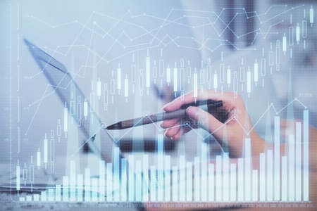 Multi exposure of woman hands typing on computer and financial graph hologram drawing. Stock market...