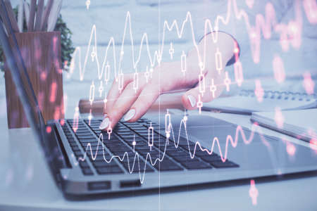 Multi exposure of woman hands typing on computer and forex chart hologram drawing. Stock market...