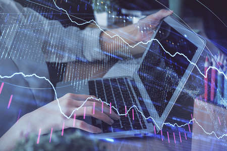 Double exposure of woman hands typing on computer and forex chart hologram drawing. Stock market...