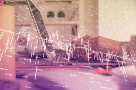 Double exposure of woman hands typing on computer and forex chart hologram drawing. Stock market...