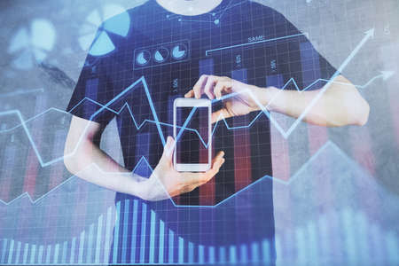 Double exposure of mans hands holding and using a digital device and forex graph drawing. Financial...