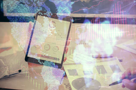 Double exposure of mans hands holding and using a digital device and forex graph drawing. Financial market concept.の写真素材