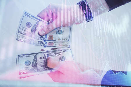 Multi exposure of financial graph drawing hologram and USA dollars bills and man hands. Analysis concept.の写真素材