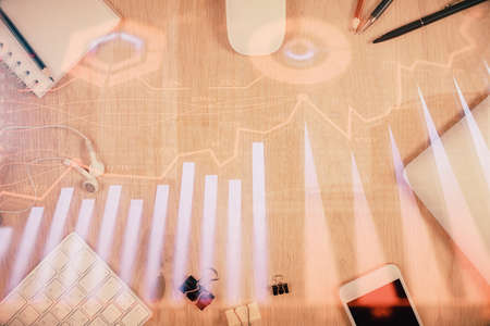 Multi exposure of forex graph hologram over desktop with phone. Top view. Mobile trade platform concept.の写真素材