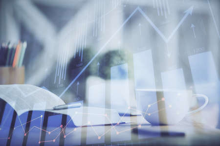 Multi exposure of forex graph drawing and desktop with coffee and items on table background. Concept of financial market tradingの写真素材