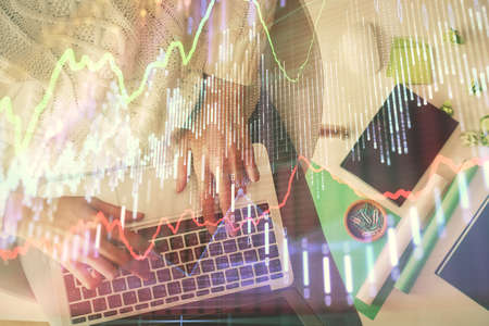 Multi exposure of woman hands working on computer and forex chart hologram drawing. Top View. Financial analysis concept.の写真素材