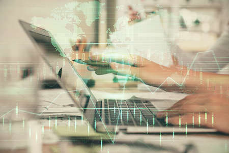Multi exposure of woman hands typing on computer and financial graph hologram drawing. Stock market...