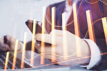 Multi exposure of mans hands holding and using a digital phone and forex graph drawing. Financial...