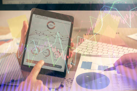 Multi exposure of mans hands holding and using a phone and financial chart drawing. Market analysis...