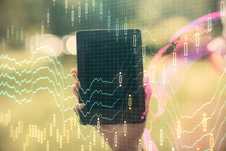 Double exposure of forex chart sketch hologram and woman holding and using a mobile device....