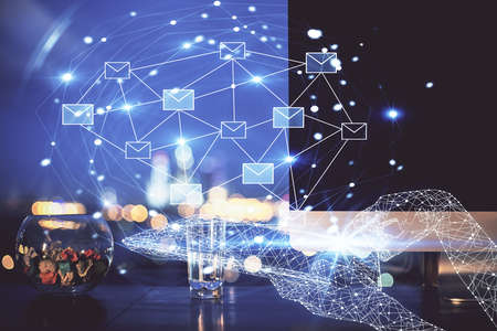 Desktop computer background in office and flying envelops hologram drawing. Double exposure. Electronic mail concept.の写真素材