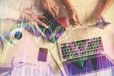 Double exposure of man and woman working together and financial chart hologram drawing. market...