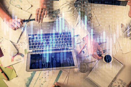 Double exposure of man and woman working together and financial graph hologram. Business concept....