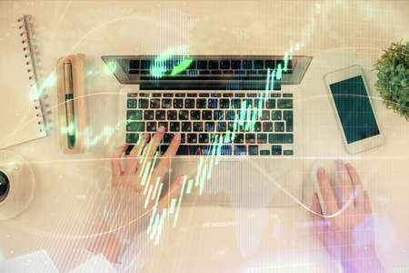 Multi exposure of woman hands working on computer and forex chart hologram drawing. Top View....