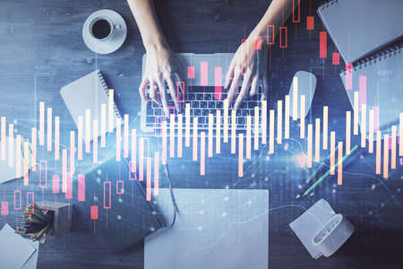 Multi exposure of woman hands working on computer and forex chart hologram drawing. Top View....