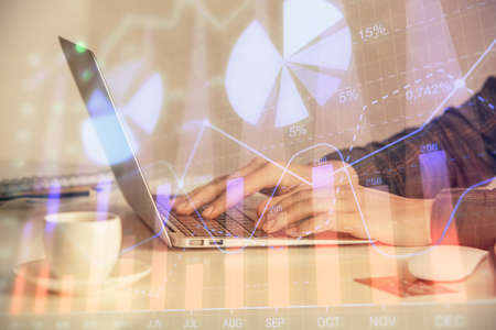Double exposure of businesswoman hands typing on computer and forex graph hologram drawing. Financial analysis concept.の写真素材