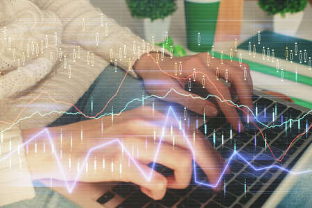 Double exposure of woman hands typing on computer and forex chart hologram drawing. Stock market...