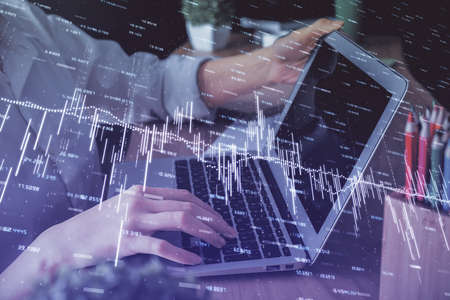 Double exposure of woman hands typing on computer and forex chart hologram drawing. Stock market...