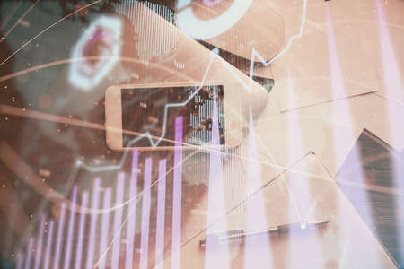 Multi exposure of forex graph hologram over desktop with phone. Top view. Mobile trade platform...