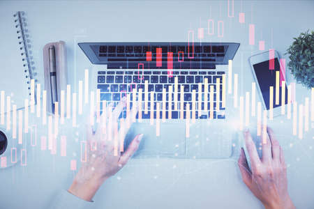 Double exposure of woman hands working on computer and forex chart hologram drawing. Top View....