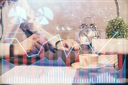 Double exposure of mans hands holding and using a phone and financial graph drawing. Analysis...