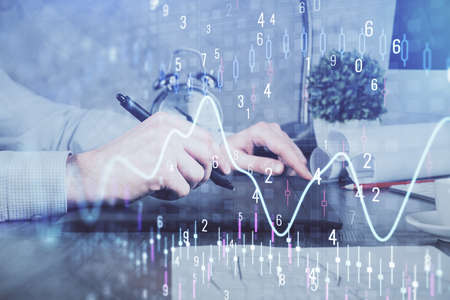 Double exposure of mans hands holding and using a phone and financial graph drawing. Analysis...