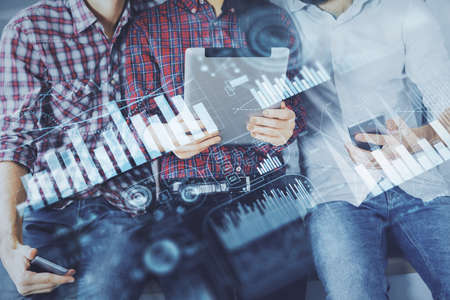 Double exposure of forex graph drawing and man and woman working together holding and using a mobile device. Trade concept.の写真素材