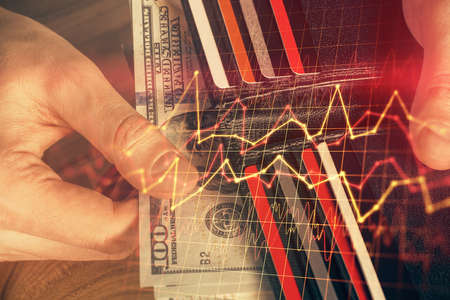 Multi exposure of forex graph drawing hologram and USA dollars bills and man hands. Technical...