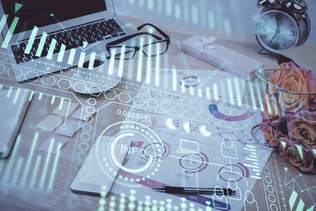 Computer on desktop in office with technology theme hologram. Double exposure. Tech concept.