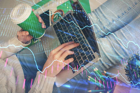 Double exposure of woman hands typing on computer and forex chart hologram drawing. Stock market...