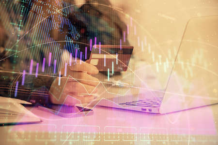 Multi exposure of woman on-line shopping holding a credit card and financial graph drawing. Stock...