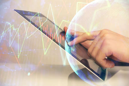 Multi exposure of mans hands holding and using a digital phone and forex graph drawing. Financial...