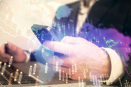 Multi exposure of mans hands holding and using a digital phone and forex graph drawing. Financial...