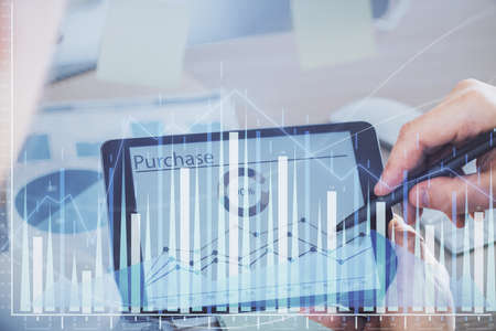 Double exposure of mans hands holding and using a phone and financial chart drawing. Market analysis...