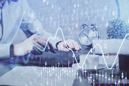 Double exposure of mans hands holding and using a phone and financial graph drawing. Analysis...
