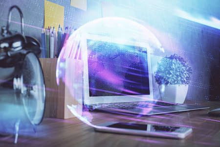 Computer on desktop in office with technology theme hologram. Double exposure. Tech concept.の写真素材