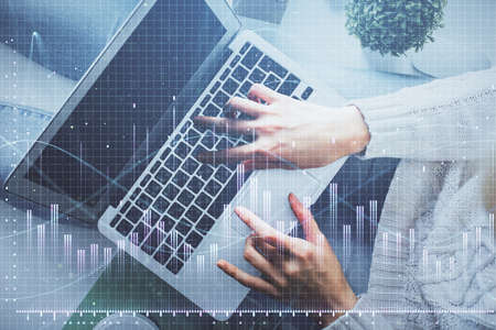 Double exposure of woman hands working on computer and forex chart hologram drawing. Top View....