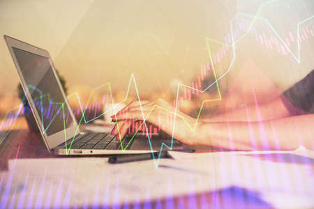 Double exposure of businesswoman hands typing on computer and forex chart hologram drawing....