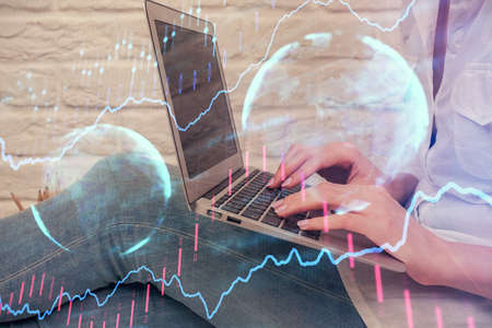 Multi exposure of woman hands typing on computer and forex chart hologram drawing. Stock market...