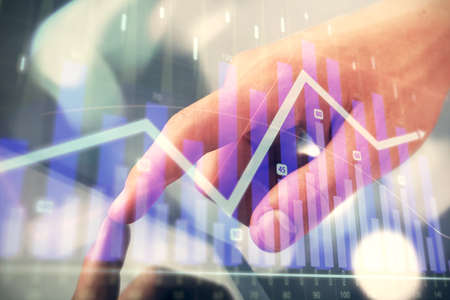 Multi exposure of mans hands holding and using a phone and financial chart drawing. Market analysis...