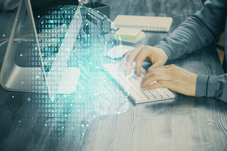 Man typing on keyboard background with brain hologram. Concept of big Data. Double exposure.の写真素材